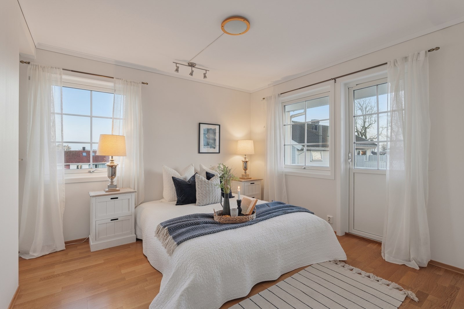 Lyst og innbydende hovedsoverom med store vinduer som gir rikelig naturlig lys og en luftig atmosfære. Rommet har god plass til dobbeltseng og nattbord, og har utgang til balkong for ekstra komfort Galleribilde