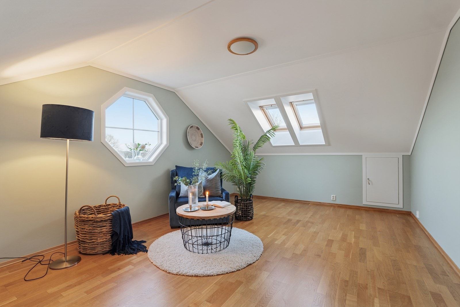 Lys og koselig loftsstue med skråtak. Rommet har både takvinduer og et karakteristisk åttekantet vindu. Perfekt som ekstra stue, TV-rom eller hjemmekontor. Galleribilde