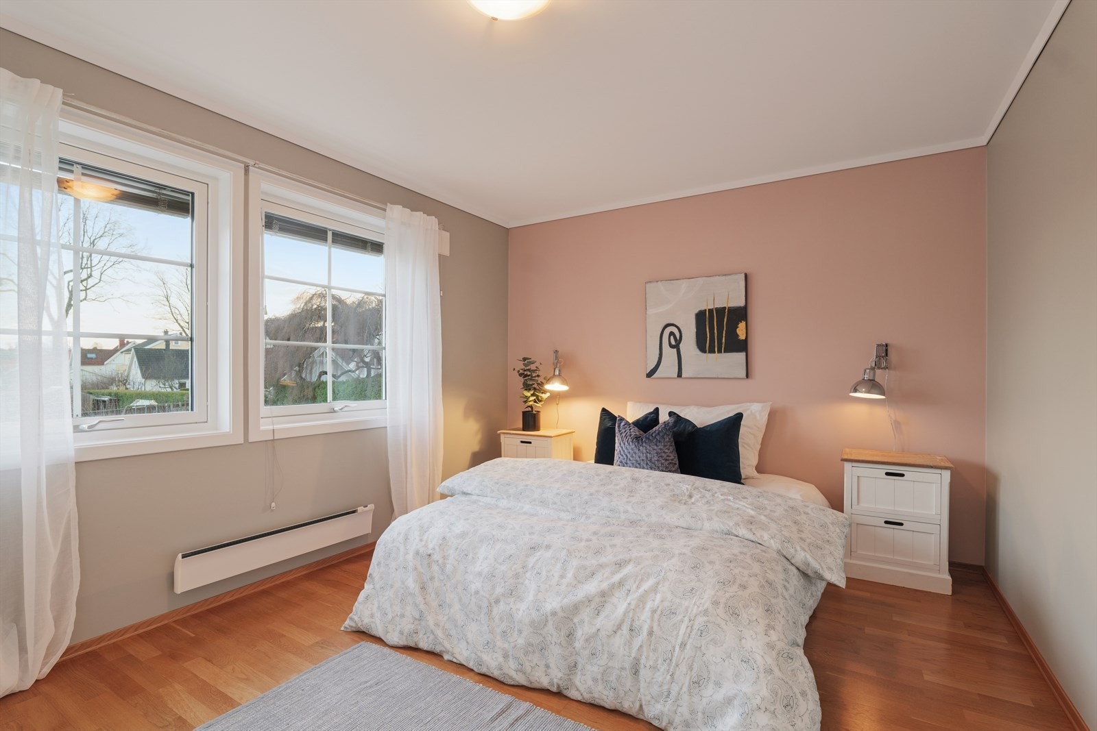 Soverom 3 - Rommet har en varm og moderne atmosfære med en delikat kontrastvegg i dus rosa tone, som gir et stilfullt preg. Det er god plass til dobbeltseng og nattbord. Galleribilde