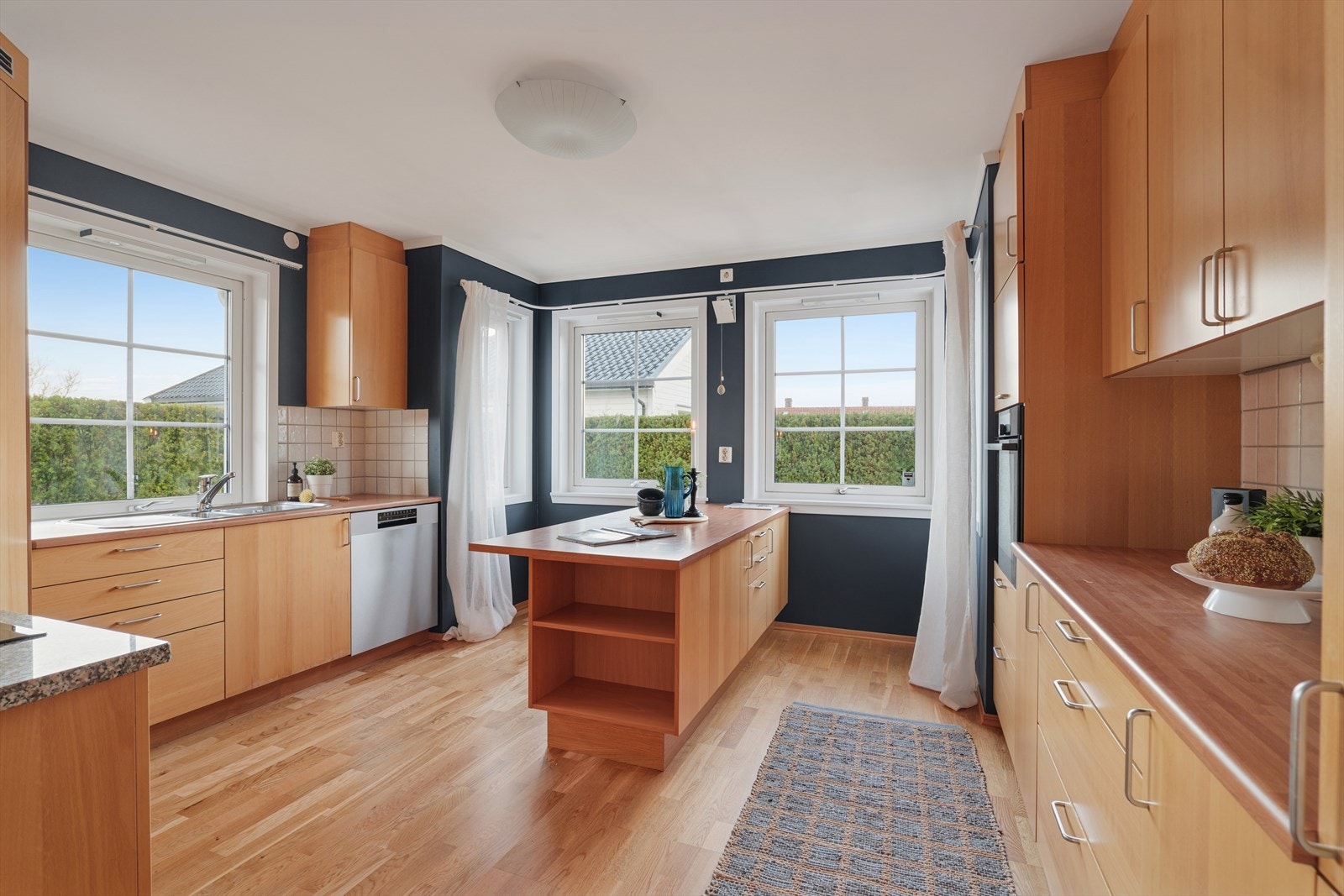 Store vinduer gir flott lysinnslipp og en hyggelig atmosfære - perfekt for både matlaging og sosiale måltider Galleribilde