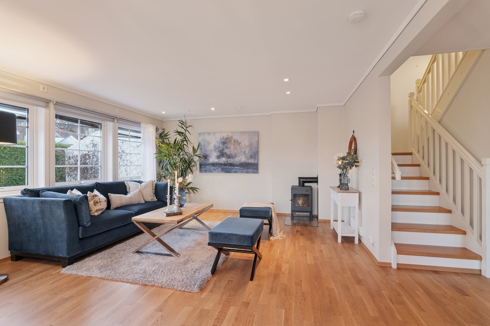 Lys og romslig stue med store vindusflater og god plass til sittegruppe. Trappen til 2. etasje gir en fin romfølelse og binder etasjene sammen på en elegant måte Galleribilde