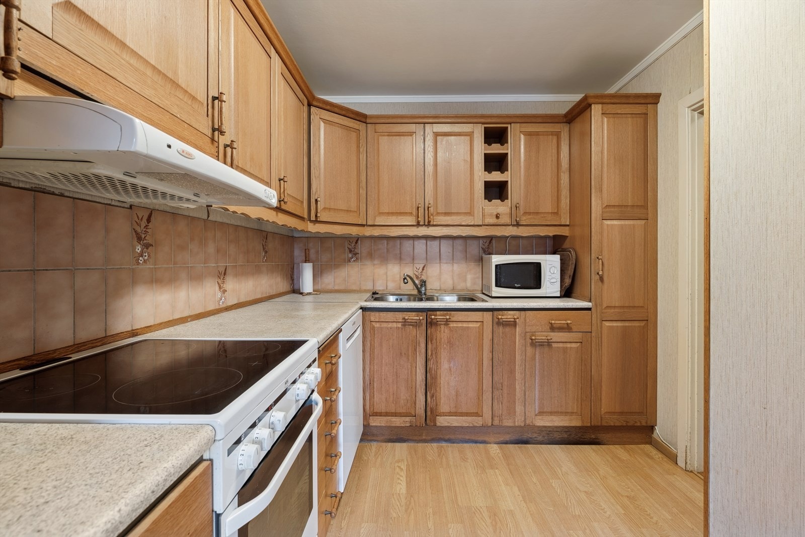 Kjøkkenet har godt med skap- og benkeplass, samt praktiske nisjer for komfyr og oppvaskmaskin. Galleribilde