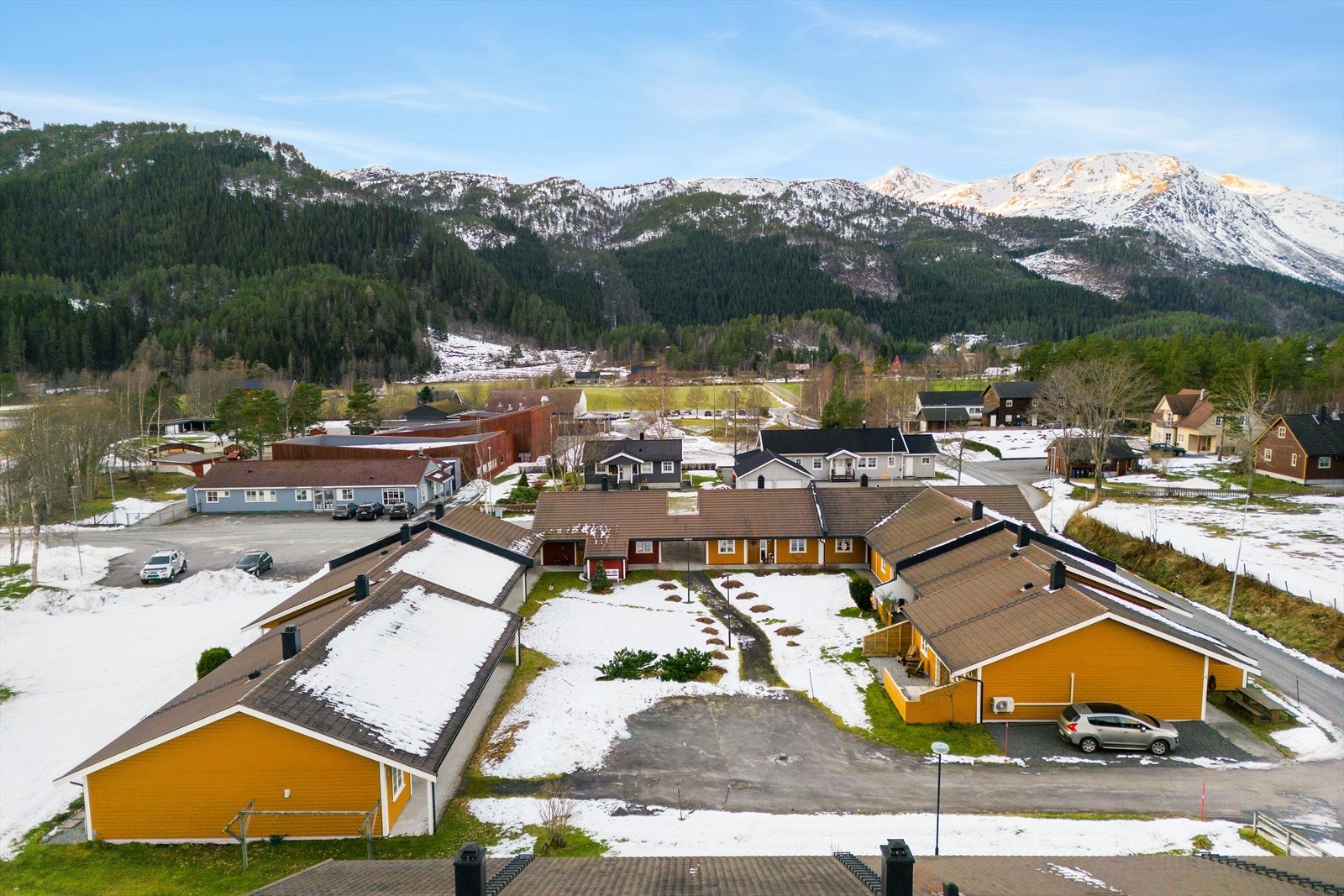 Dronebilde over boligområdet, med fjell i bakgrunnen. Galleribilde