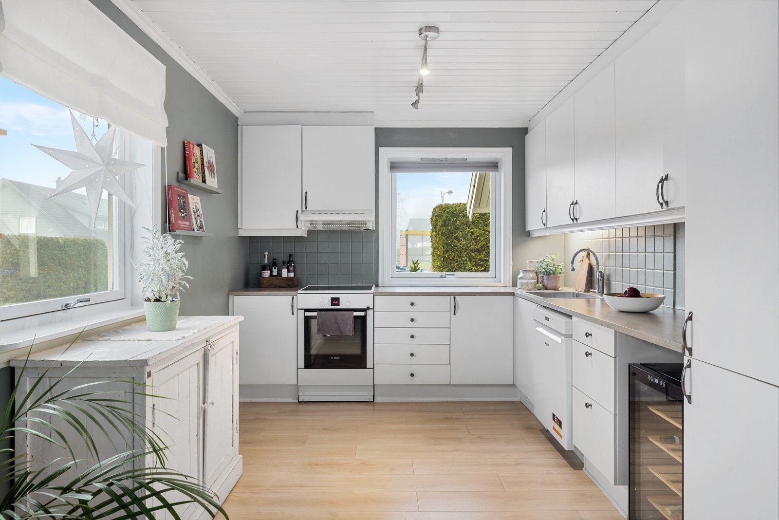 Kjøkkeninnredning med slette, hvite fronter på over- og underskap Galleribilde