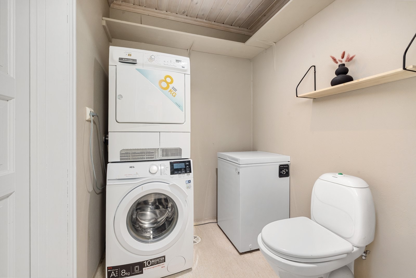 Praktisk vaskerom innredet med toalett og opplegg for vaskemaskin og tørketrommel Galleribilde