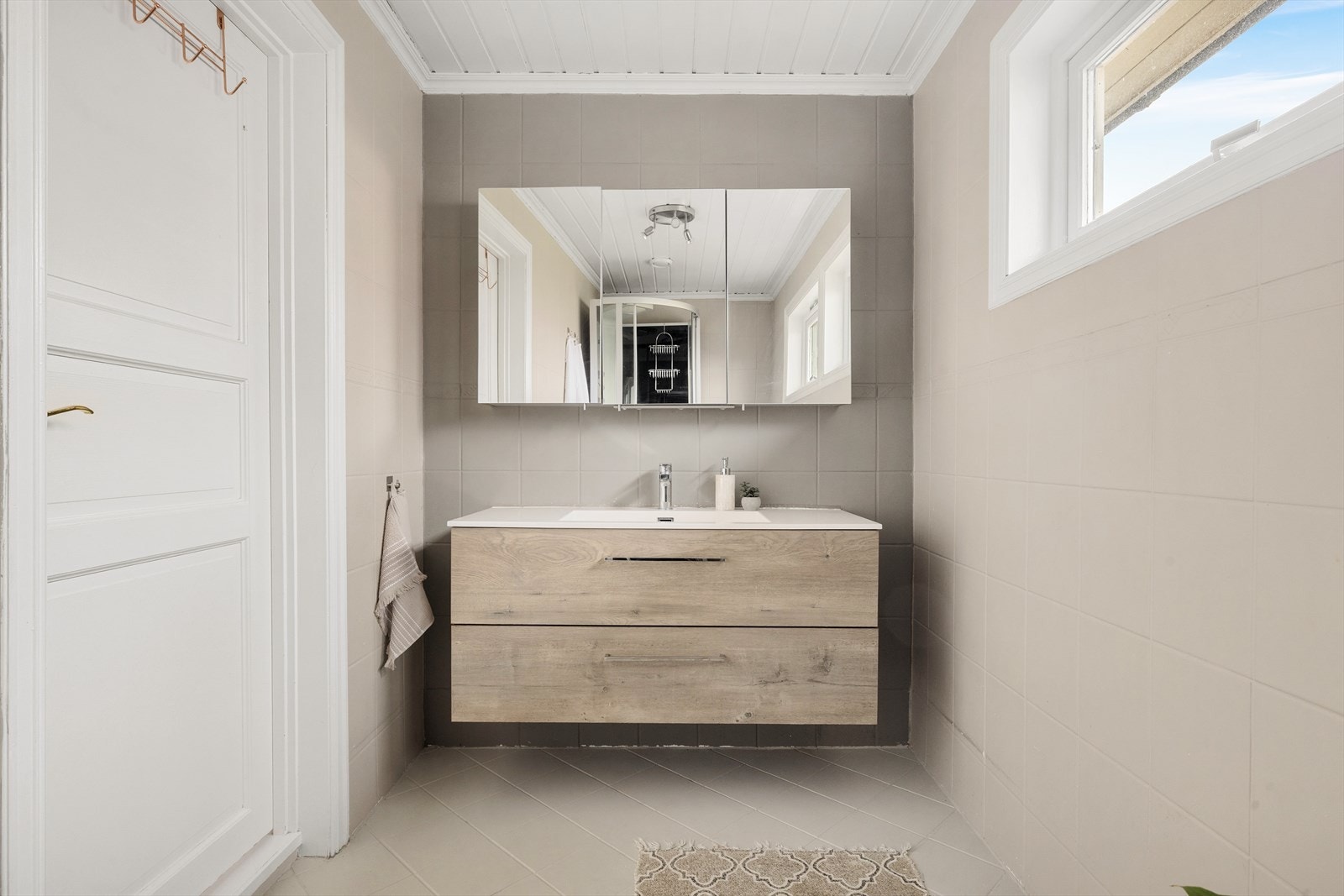 Moderne baderomsinnredning med skuffer og heldekkende servant Galleribilde