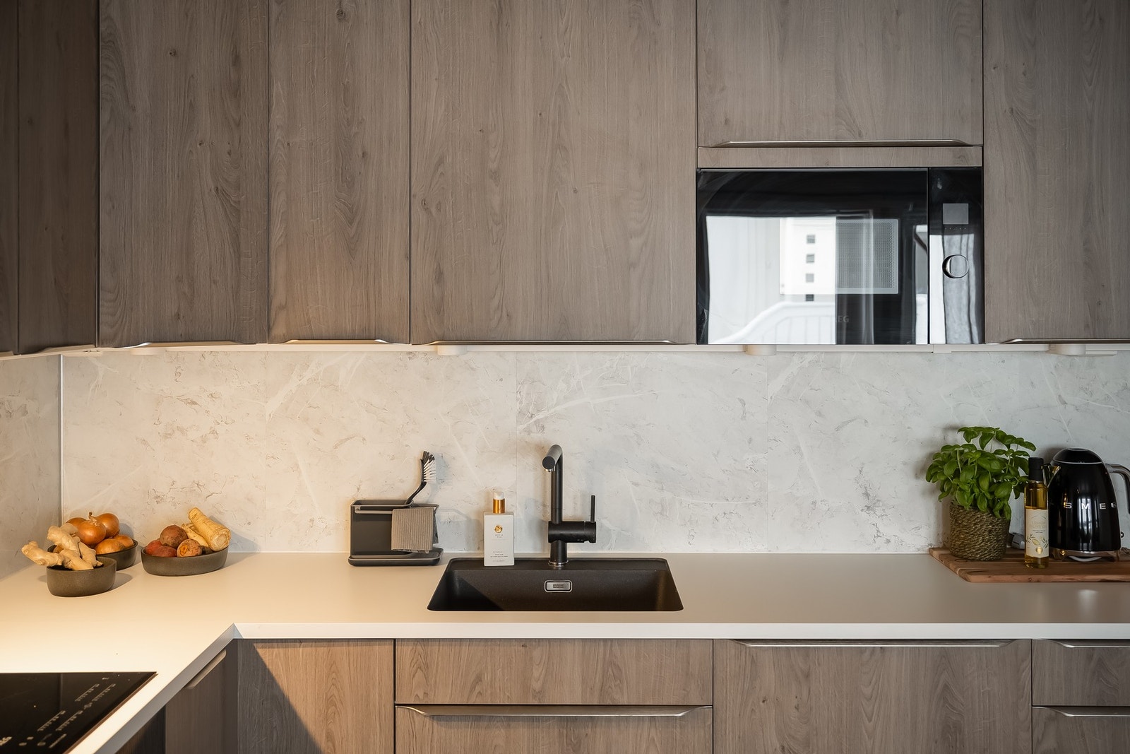 Integrerte hvitevarer fra AEG bestående av kombiskap, oppvaskmaskin, platetopp, stekeovn, mikrobølgeovn og ventilator. Galleribilde