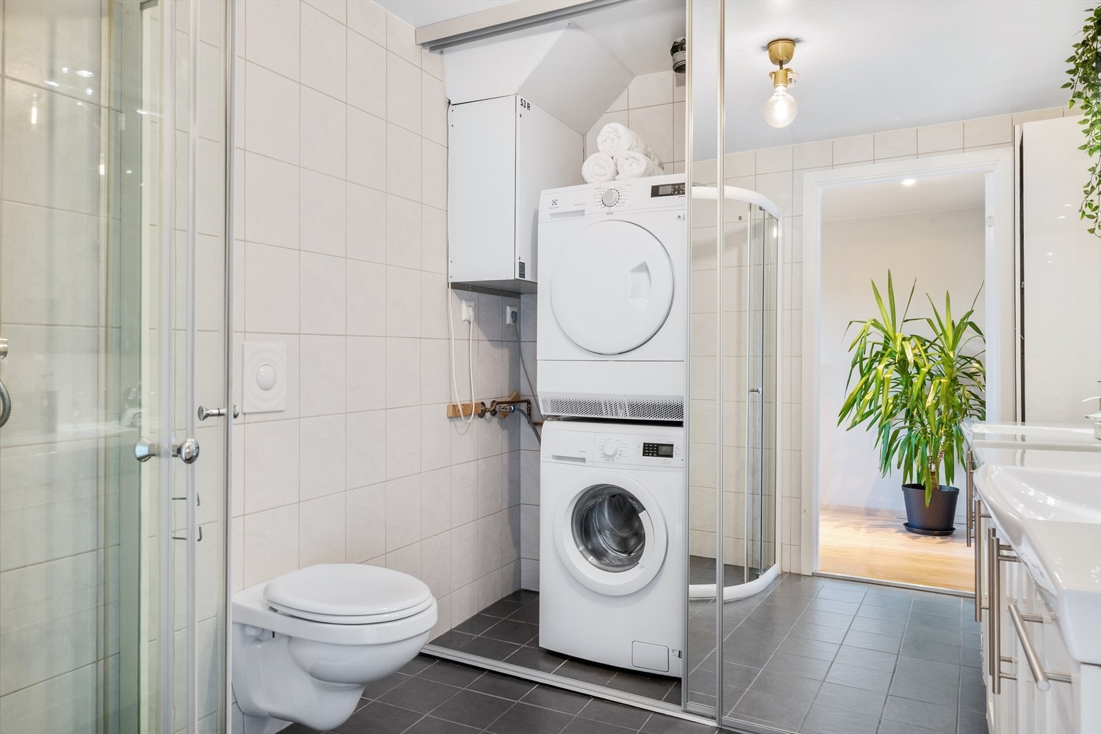Det er opplegg for både vaskemaskin og tørketrommel som er praktisk skjult bak skyvedører med speil. Galleribilde