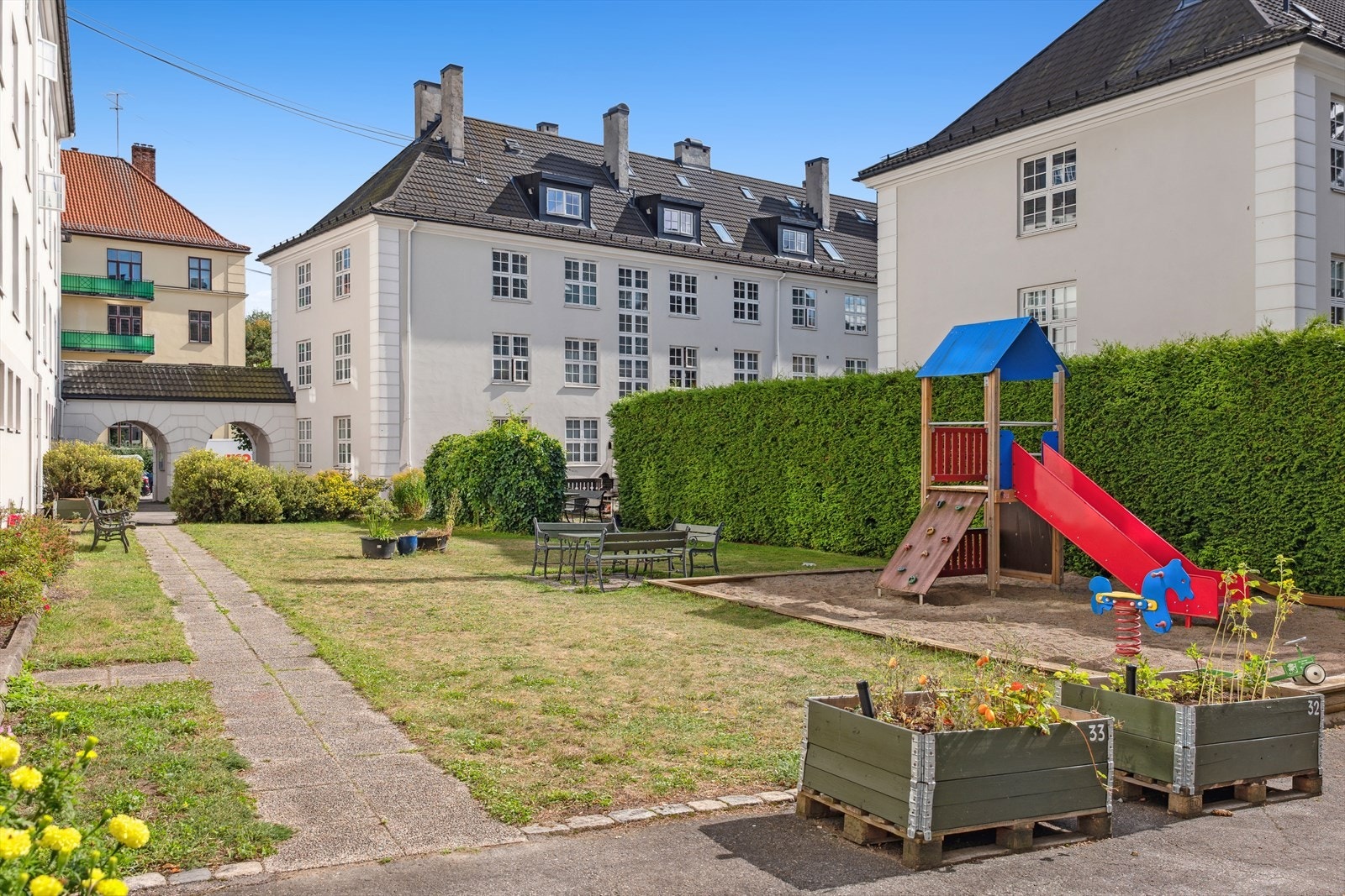 Hyggelig bakgård med sittegrupper og lekestativ til de minste. Galleribilde