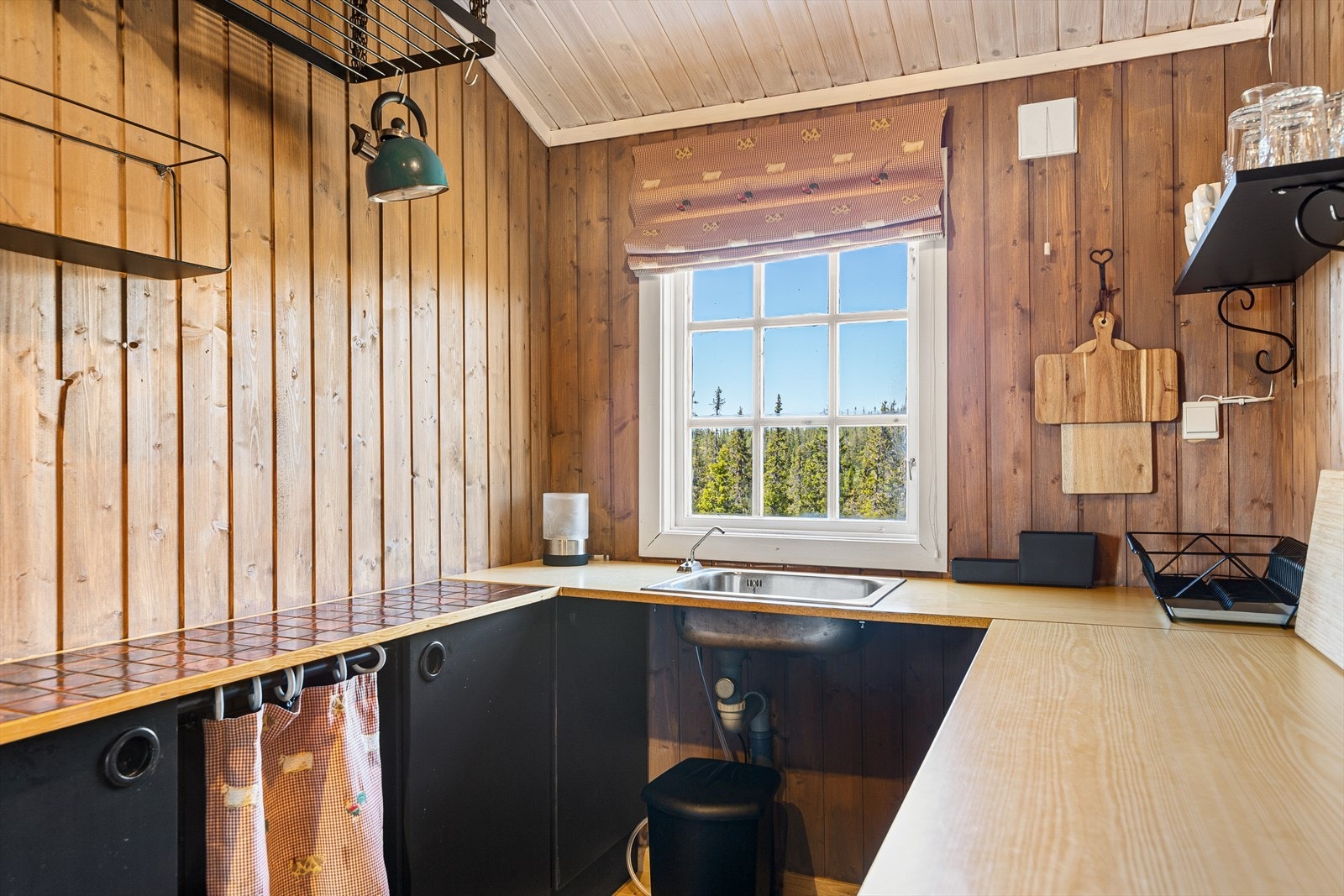 På kjøkkenet er det underskap med malte fronter og laminert benkeplate med nedfelt oppvaskkum, og avløp til terreng. Galleribilde