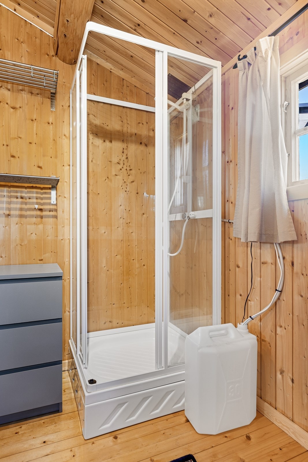 Toalettet har avløpsrør til tett tank under bygget av plast, mens avløpsrør fra vask og dusj er avsluttet under bygget. Galleribilde