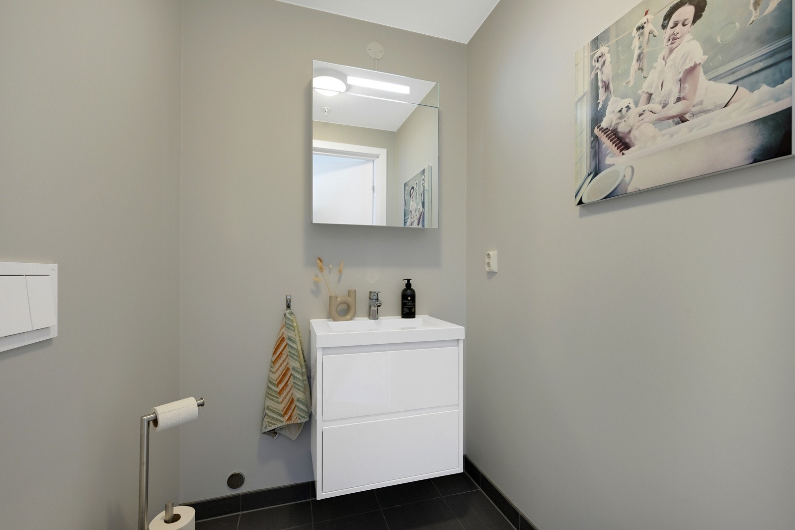 Separat og praktisk toalettrom med fliser på gulvet. Det er gulvvarme, servant, speil og veggmonert wc. Galleribilde