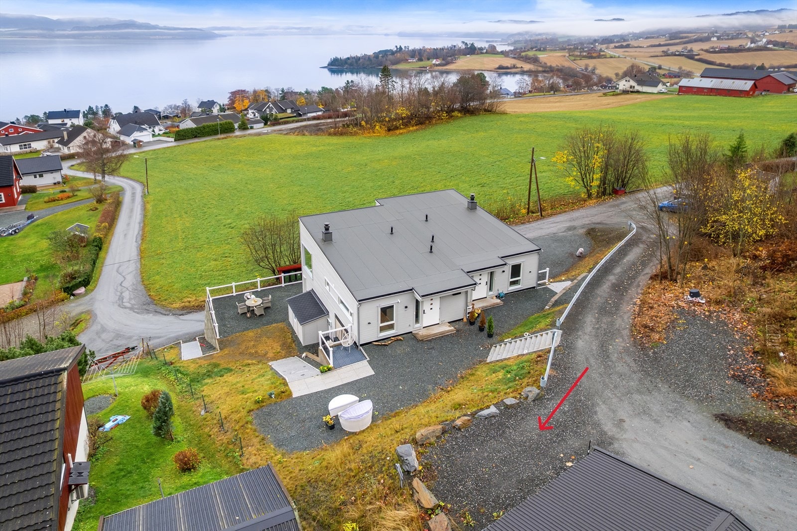 Parkeringsplassen til boligen ligger på oversiden, markert med rød pil. Galleribilde