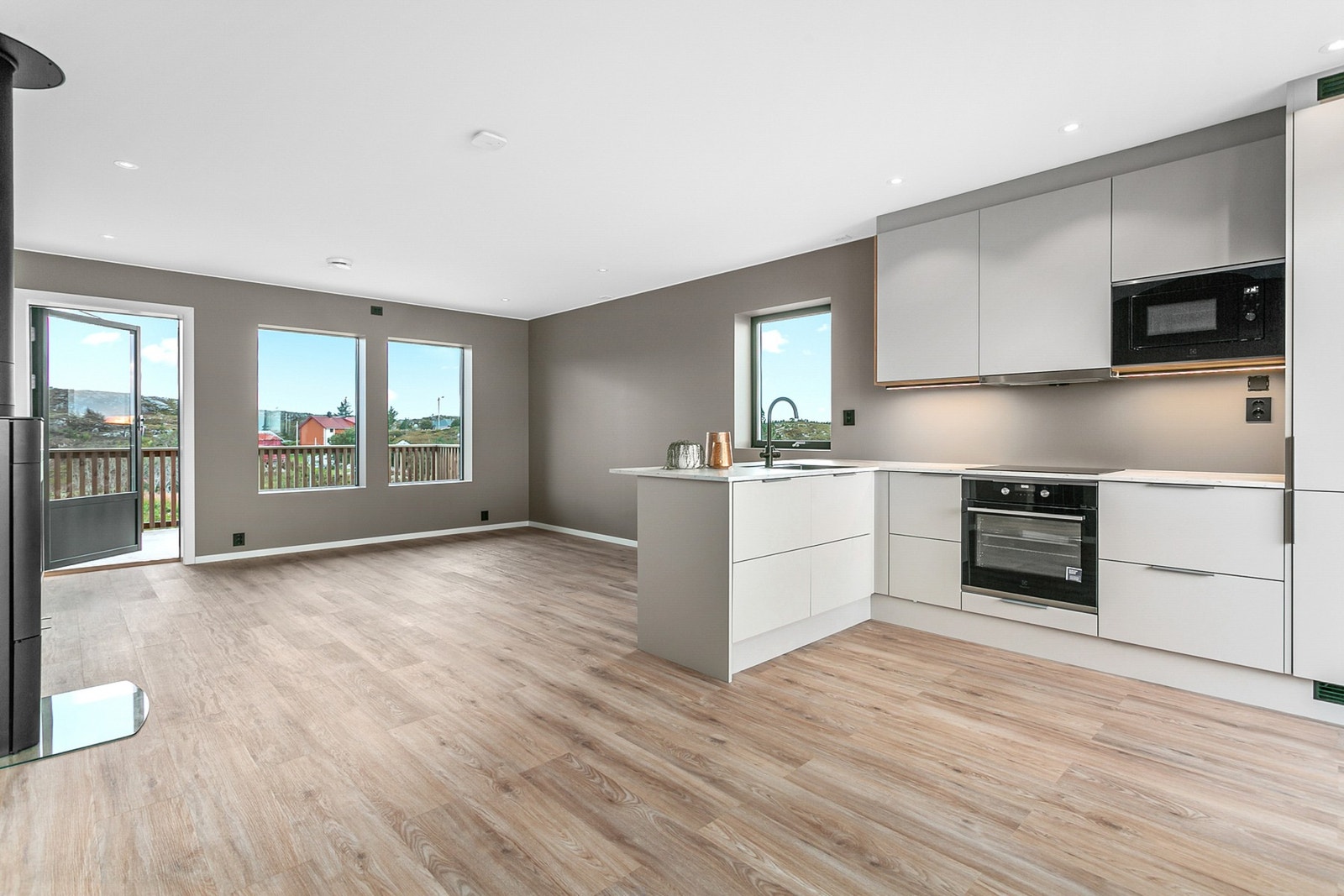 Flott kjøkken fra JKE med integrerte hvitevarer og praktisk halvøy Galleribilde