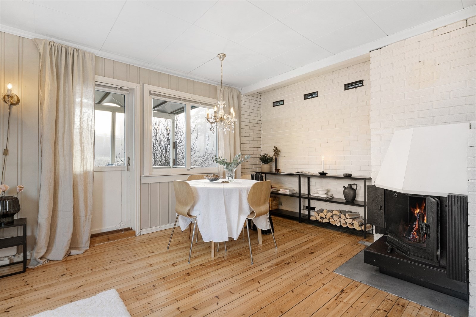 Pen stue med gulv av furu og panel på vegger malt i et lun farge. Galleribilde