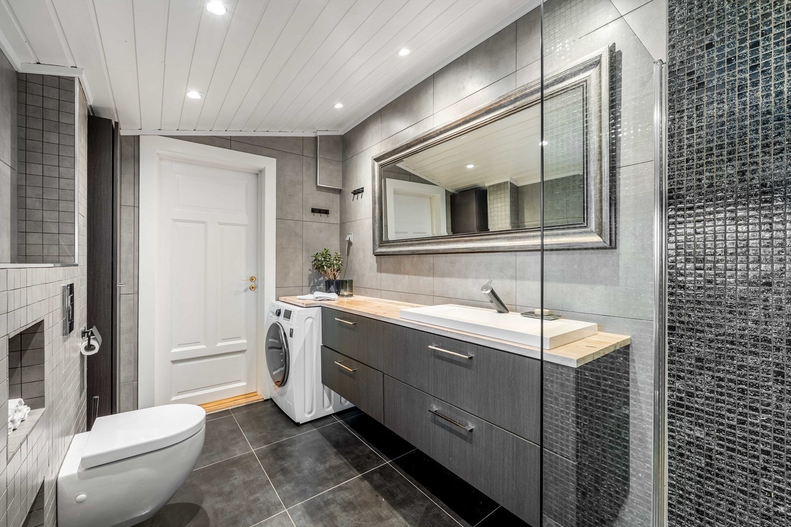 Rommet er helfliset med panel og downlights i himling. For ekstra komfort er det termostatstyrt gulvvarme. Galleribilde