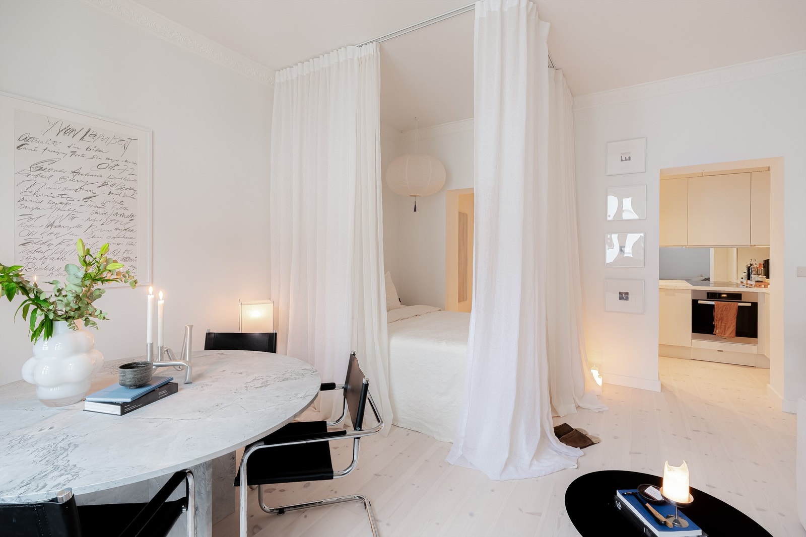 Praktisk sovesone med skinner i taket og lyse gardiner som henger som slør. Galleribilde