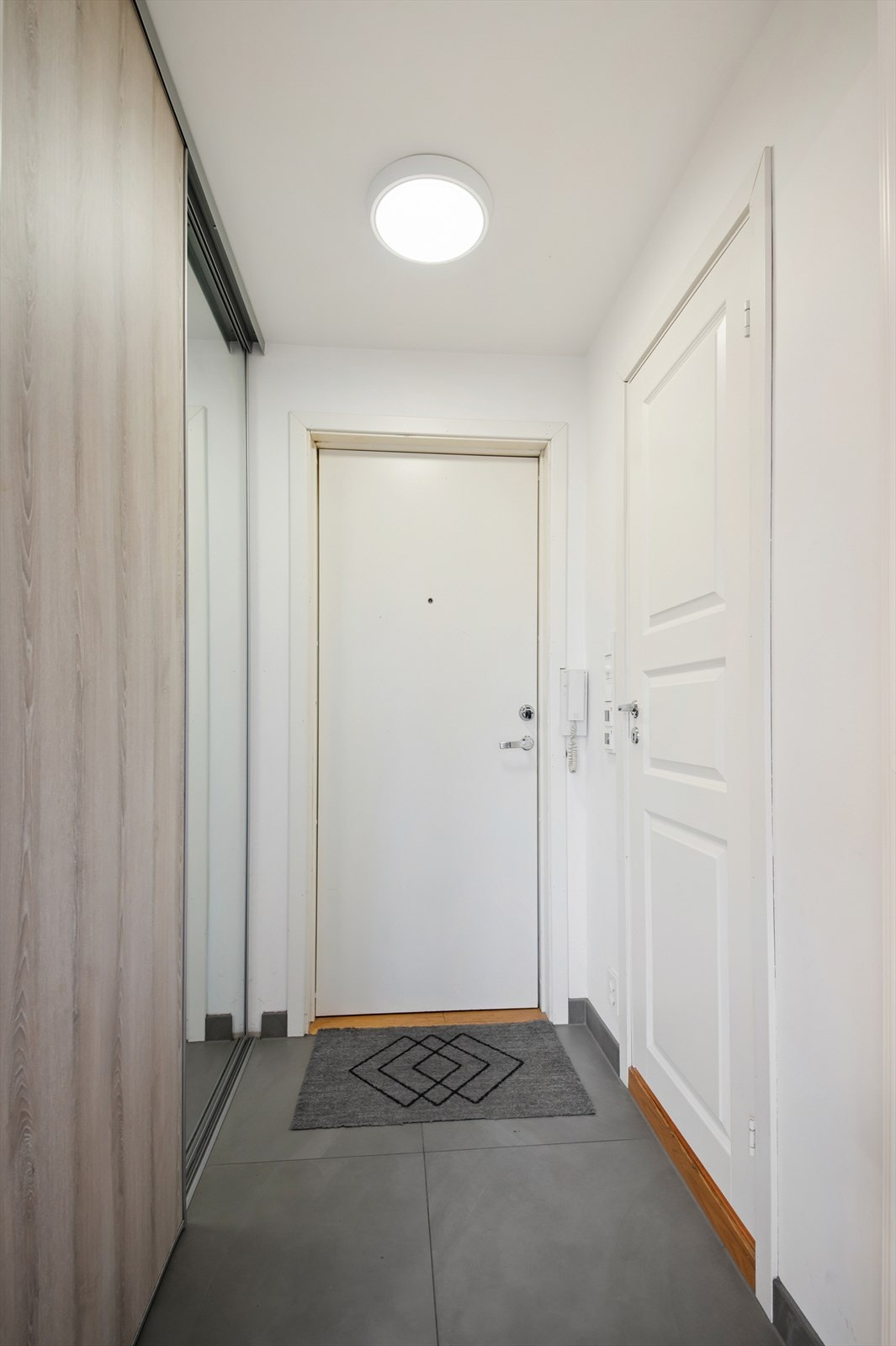 Innbydende og flislagt entré med varmekabler i gulv og et lyst fargevalg på vegger. Galleribilde