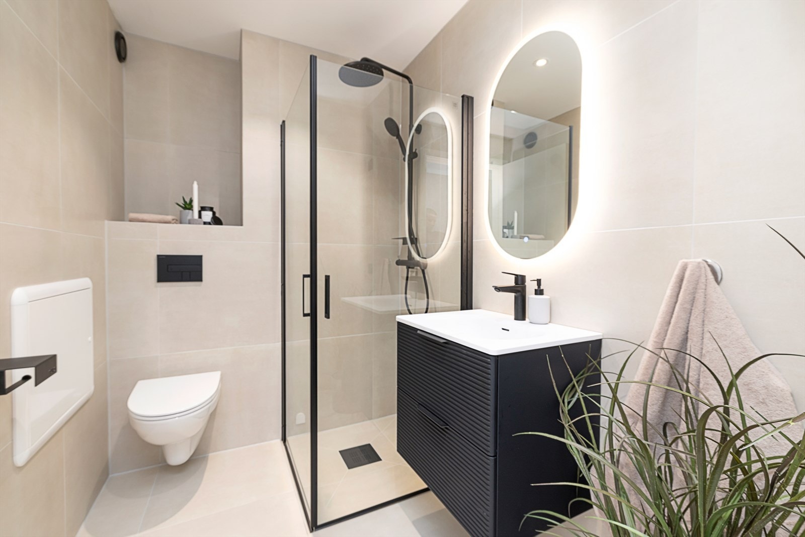 Lekkert bad bestående av baderomsinnredning, dusjhjørne og vegghengt toalett. Galleribilde