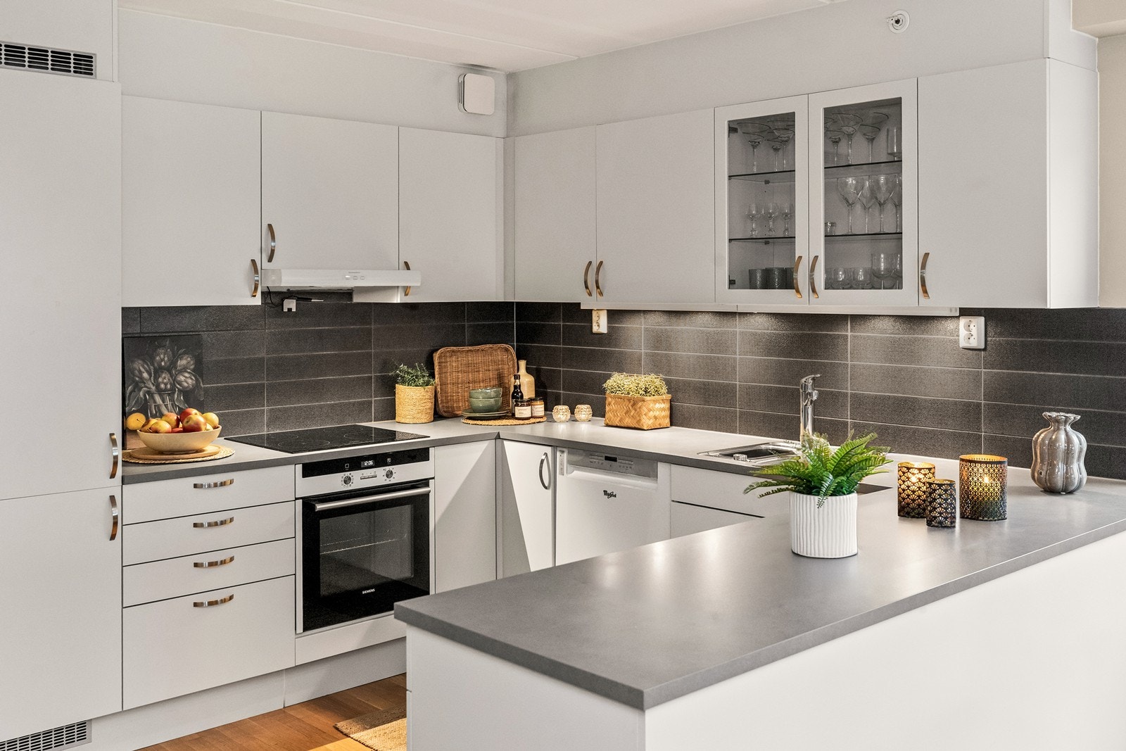 Innredningen er klassisk med hvite, slette fronter, laminat benkeplate og flislagt sprutsone. Galleribilde