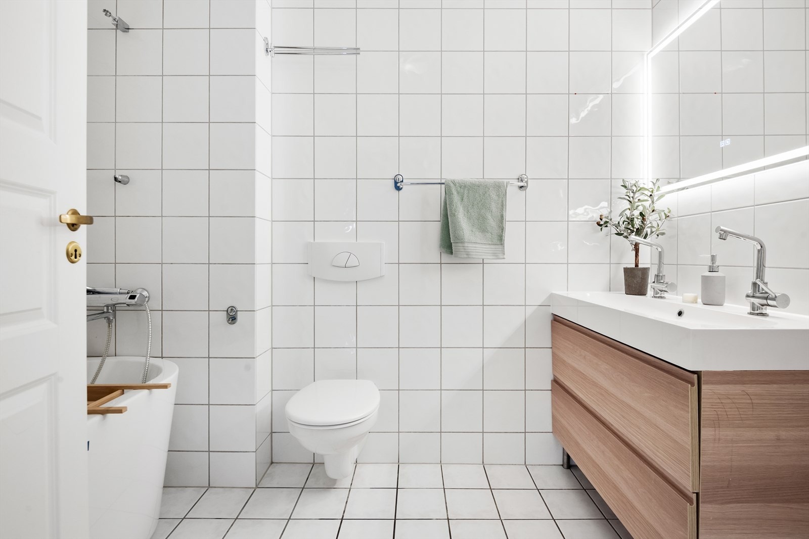 Lyst og innbydende baderom med elektrisk varme i gulvet. Det er opplegg for vaskemaskin på dette badet. Galleribilde