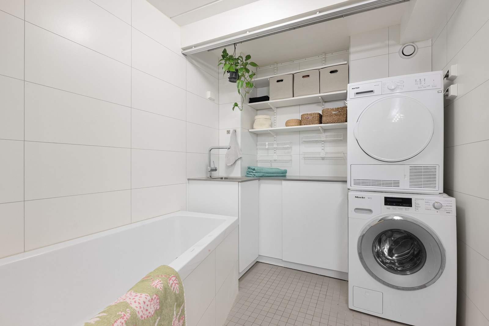 Badet har opplegg for vaskemaskin og tørketrommel, samt gode oppbevaringsløsninger i skap og hyller. Galleribilde