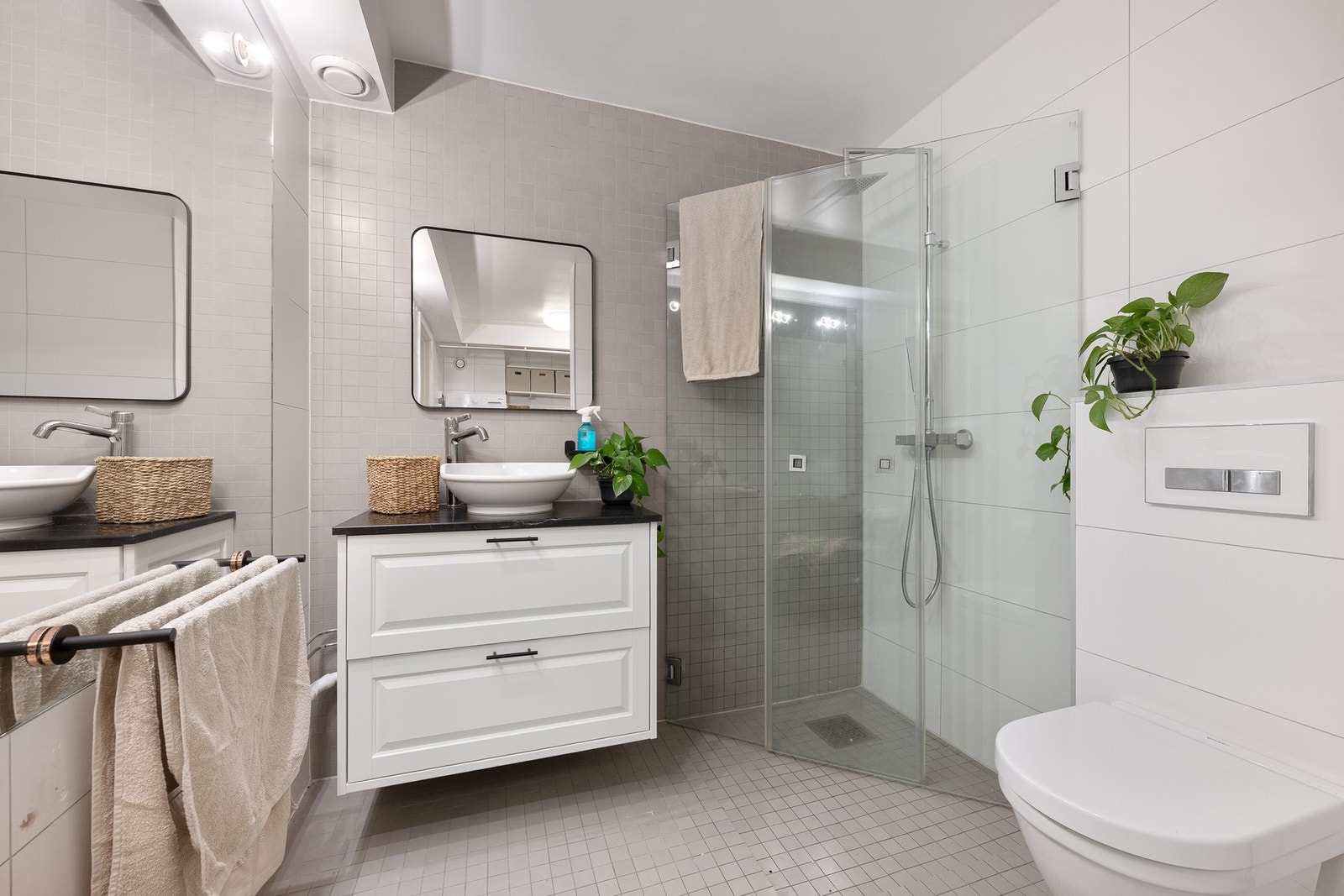 Innholdsrikt og godt utnyttet bad med flislagte gulv og vegger, varmekabler og pen innredning. Galleribilde