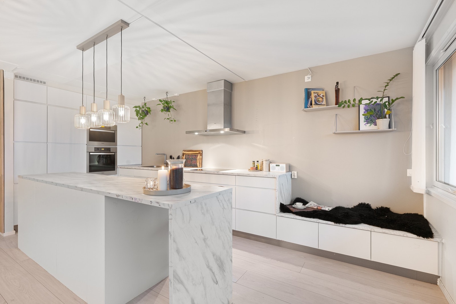 Lyst kjøkken med glatte fronter og rikelig med oppbevaringsplass i både skap og skuffer. Galleribilde