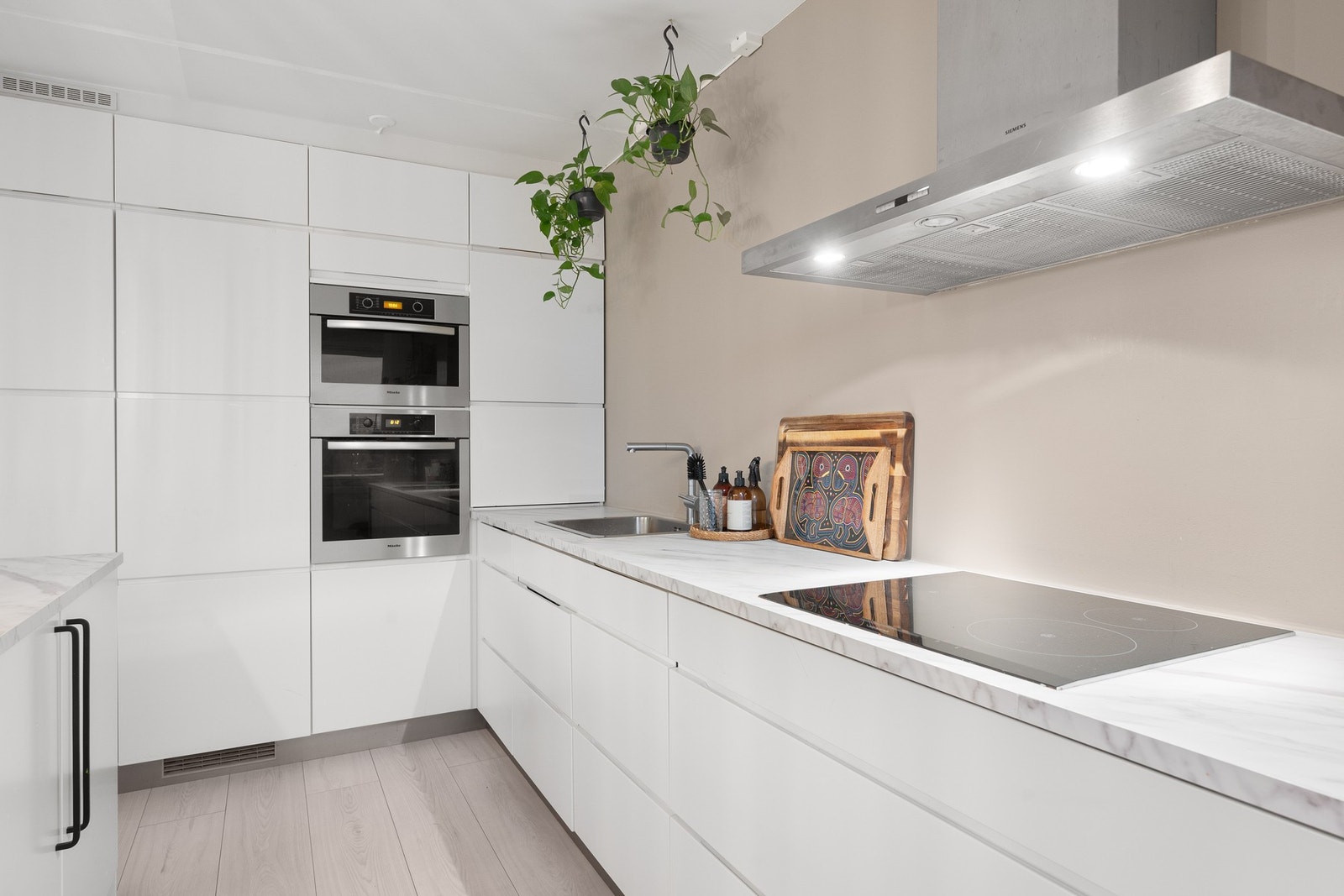 Alle hvitevarer på kjøkkenet er integrerte og medfølger. Kjøkkenet har nye benkeplater og kjøkkenøy fra 2025. Galleribilde