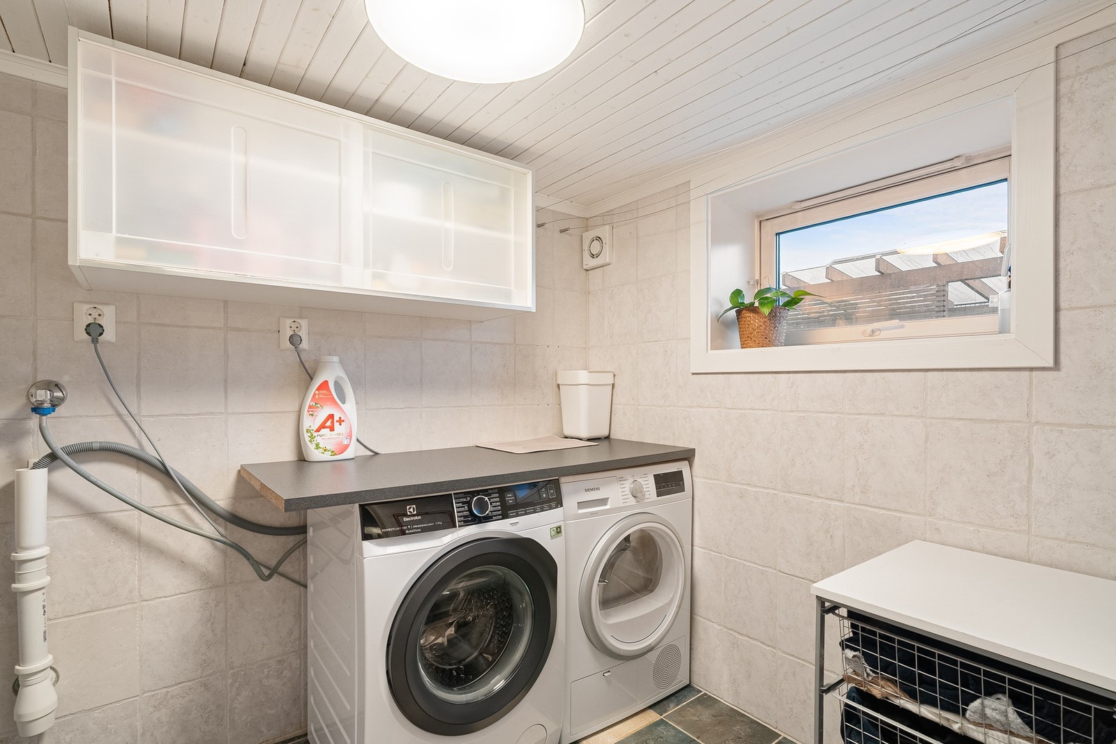 Praktisk flislagt vaskerom med mekanisk avtrekksvifte og luftevindu. Galleribilde