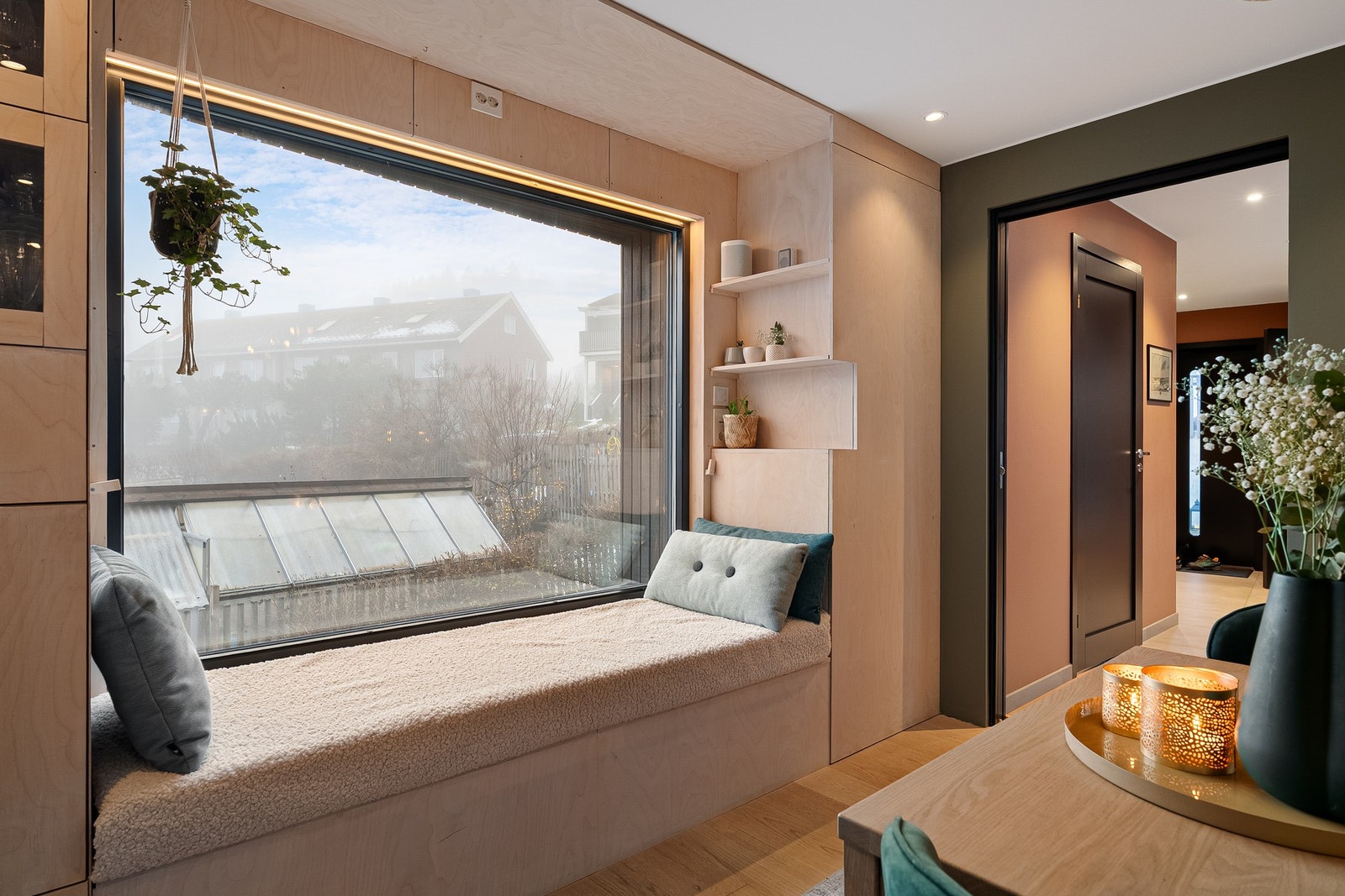 Plassbygd benk/"daybed" i stilige finérplater ved stort sørvendt vindu med fin utsikt. Praktisk skyvedør mellom entré og spisestue. Galleribilde