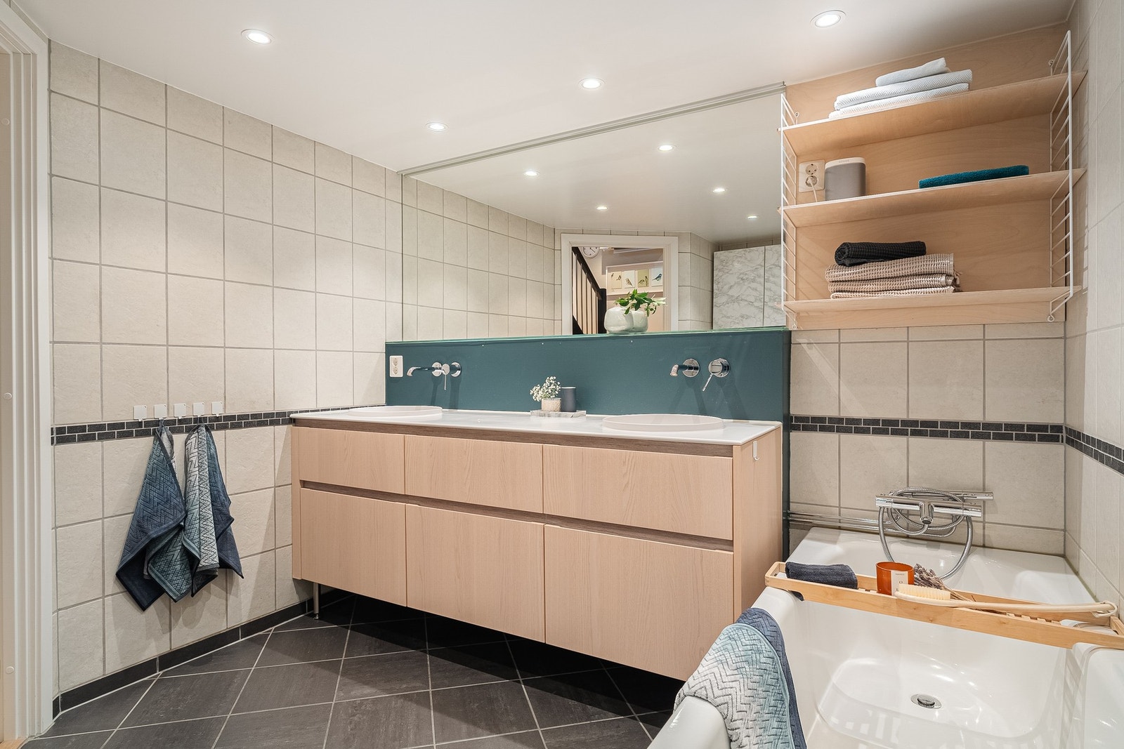 Delikat flislagt bad med med dobbelt servantskap. Downlights i himling. Galleribilde