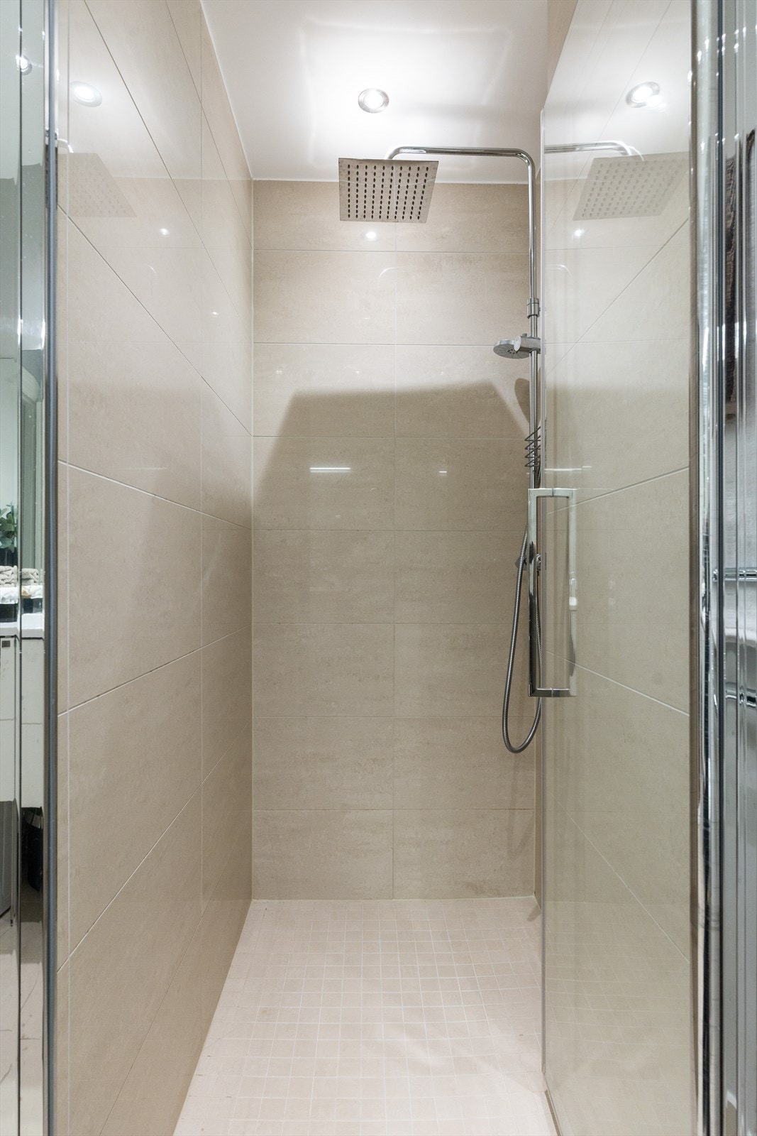 Videre har badet en romslig dusjnisje, veggmontert wc samt servantskap med ettgreps blandebatteri fra Hansgrohe. Galleribilde