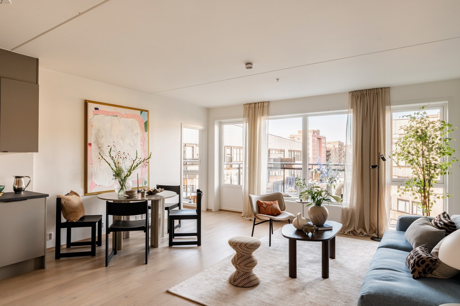 Oppholdsrommet fremstår lyst, moderne og innbydende med store vindusflater som slipper inn rikelig med dagslys. Galleribilde