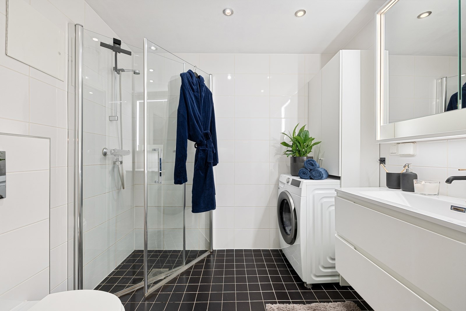 Badet er utstyrt med mekanisk avtrekk, opplegg for vaskemaskin, servant i servantskap, veggmontert wc og innfellbare dusjdører. Galleribilde