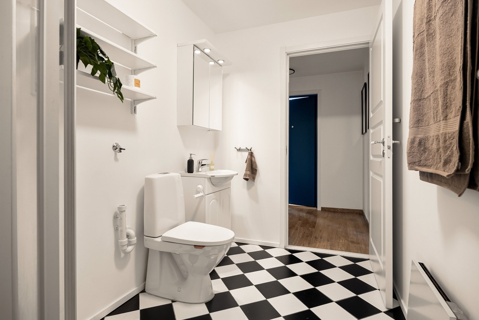 Badet består av dusjkabinett, toalett, og servant med innredning. Galleribilde