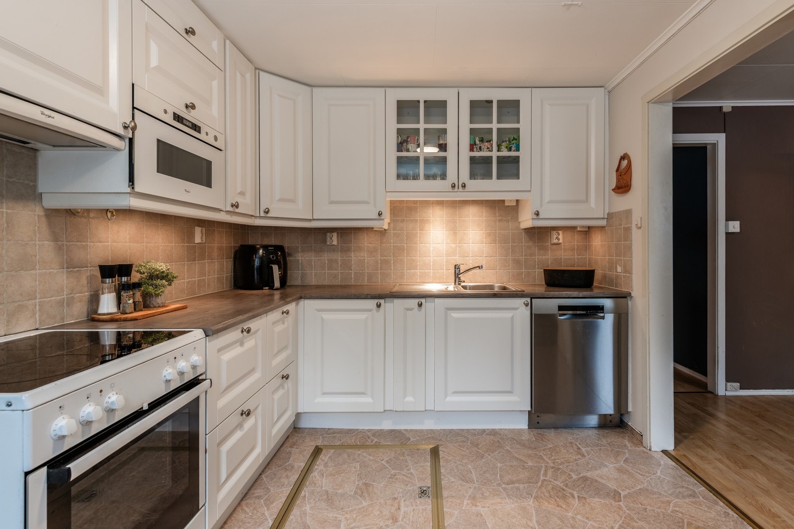 Kjøkkenet har innredning med profilerte fronter og benkeplater i laminat Galleribilde