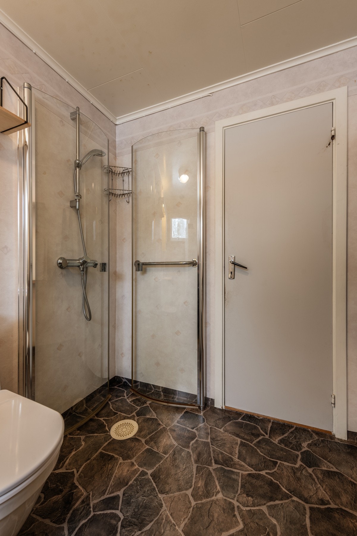 Badet har vinylbelegg på gulv og våtromstapet på vegger Galleribilde