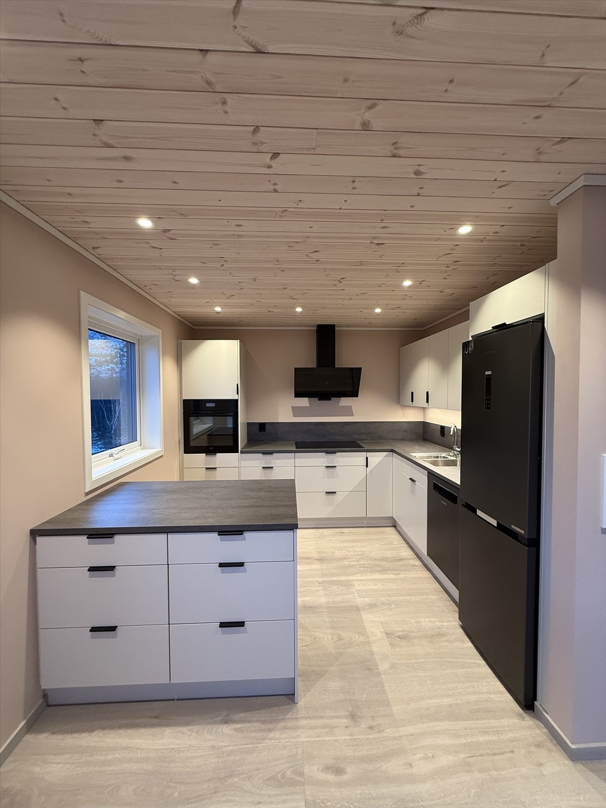 Kjøkkenet er innholdsrikt, med integrerte hvitevarer og en smart kjøkkenøy Galleribilde