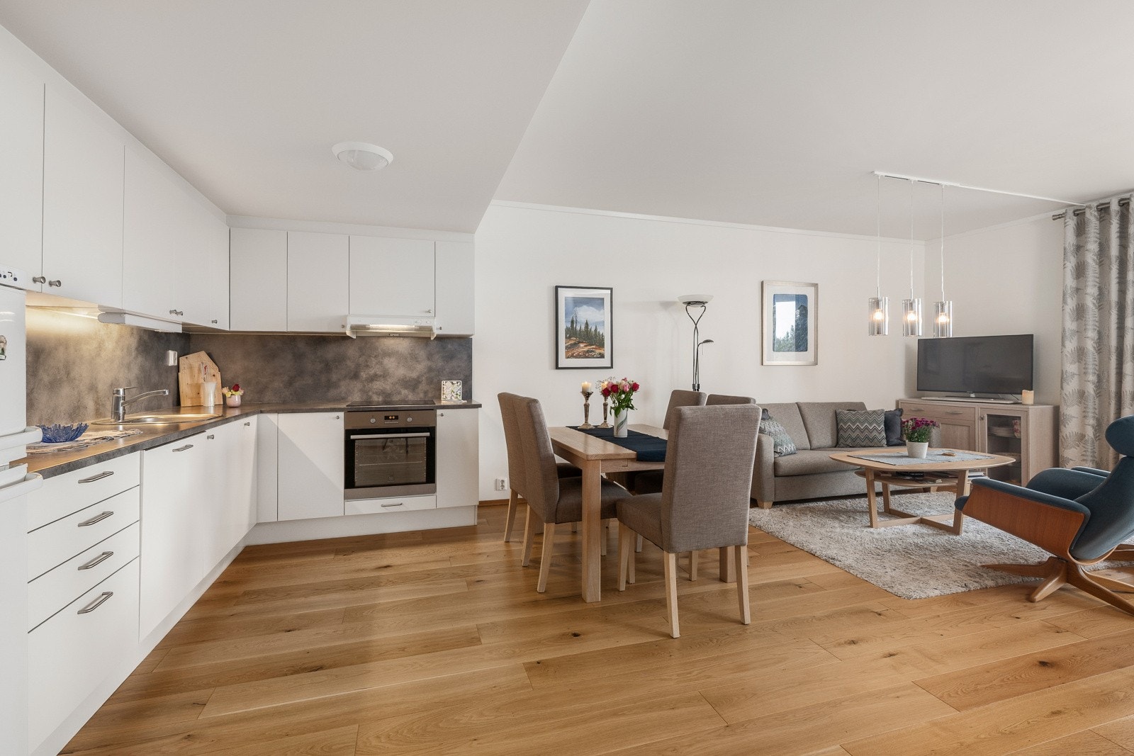 Et lyst og romslig rom med god plass til både spisegruppe og sofa. Galleribilde