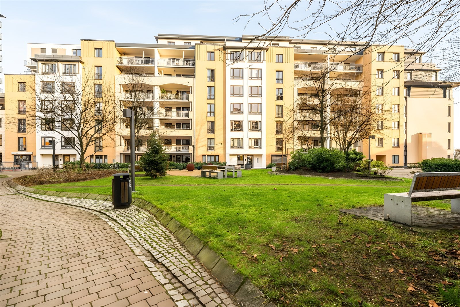 Nydelig og velholdt bakgård, opparbeidet med asfalterte gangveier, planter, busker og trær. Sittegrupper, lekeapparat og utegrill. Galleribilde