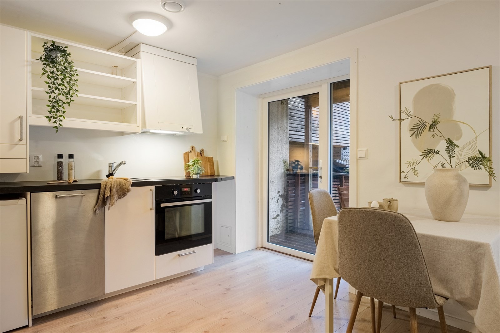 Kjøkkeninnredning med hvite fronter og laminat benkeplate. Galleribilde