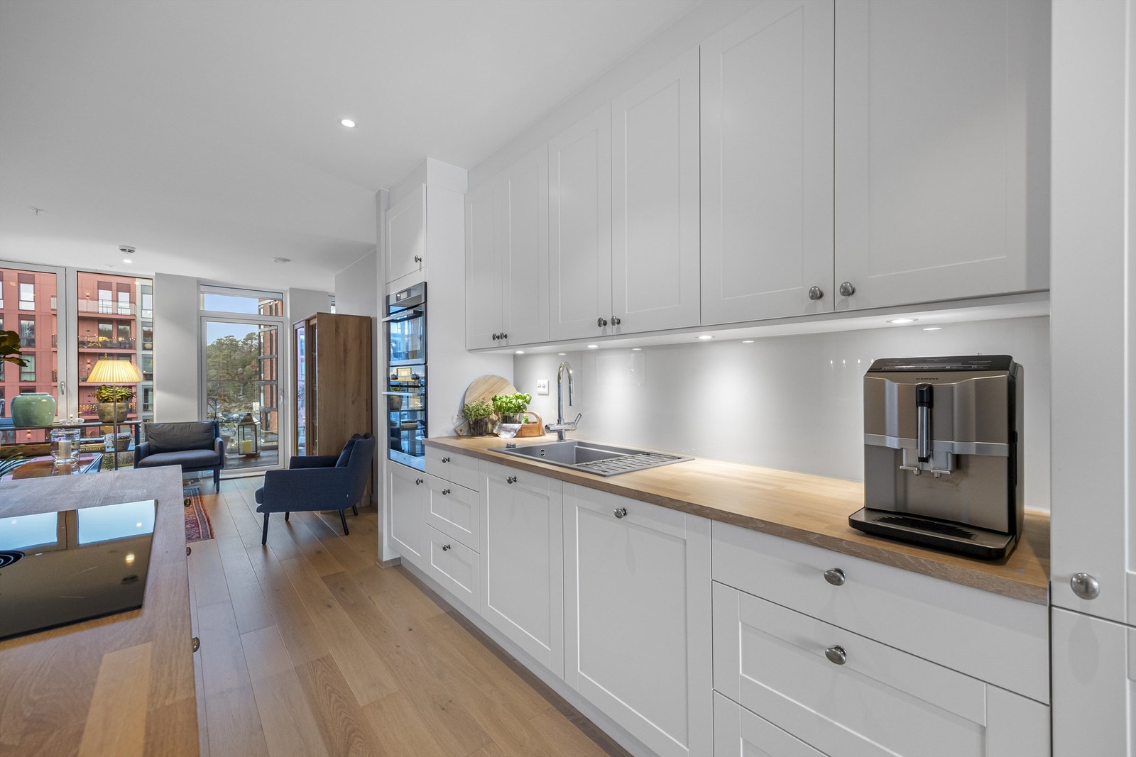 Åpen kjøkkenløsning hvor innredningen er fra Strai, integrerte hvitevarer fra AEG og Miele Galleribilde