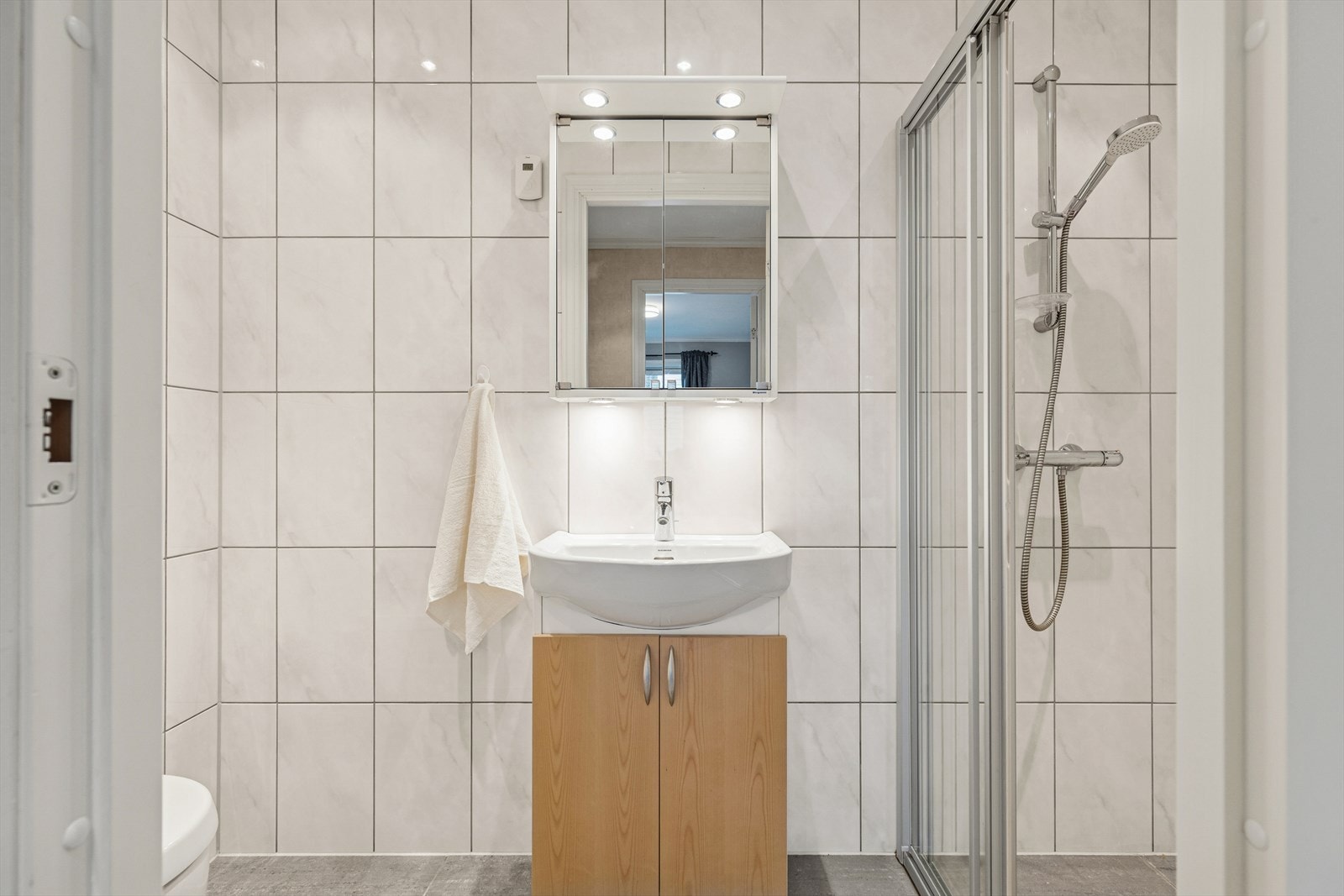 Baderom nr. 2 med dusjvegger, servant med skap og toalett. Galleribilde