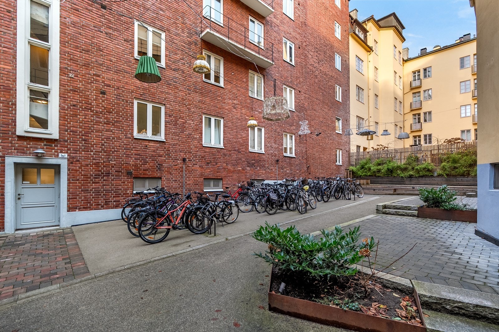 Opparbeidet bakgård med belegningsstein og sykkelparkering. Galleribilde