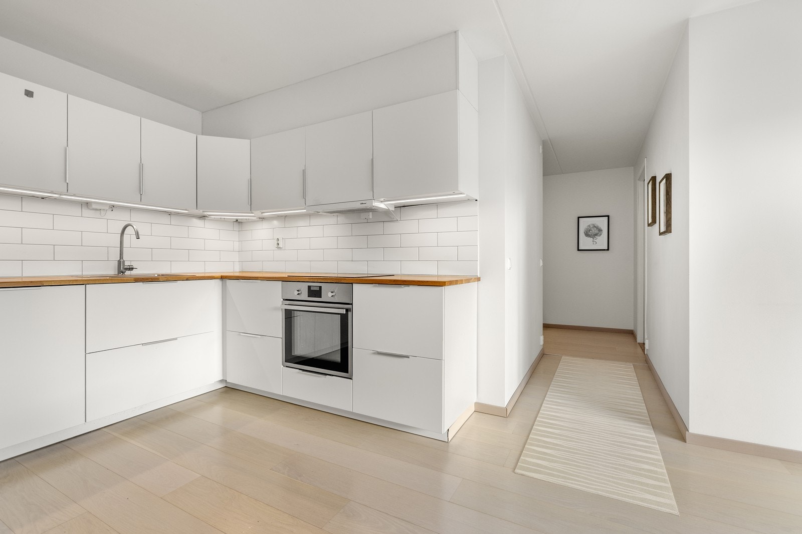 Kjøkkenet er praktisk plassert i tilknytning til leilighetens entré og gang. Galleribilde