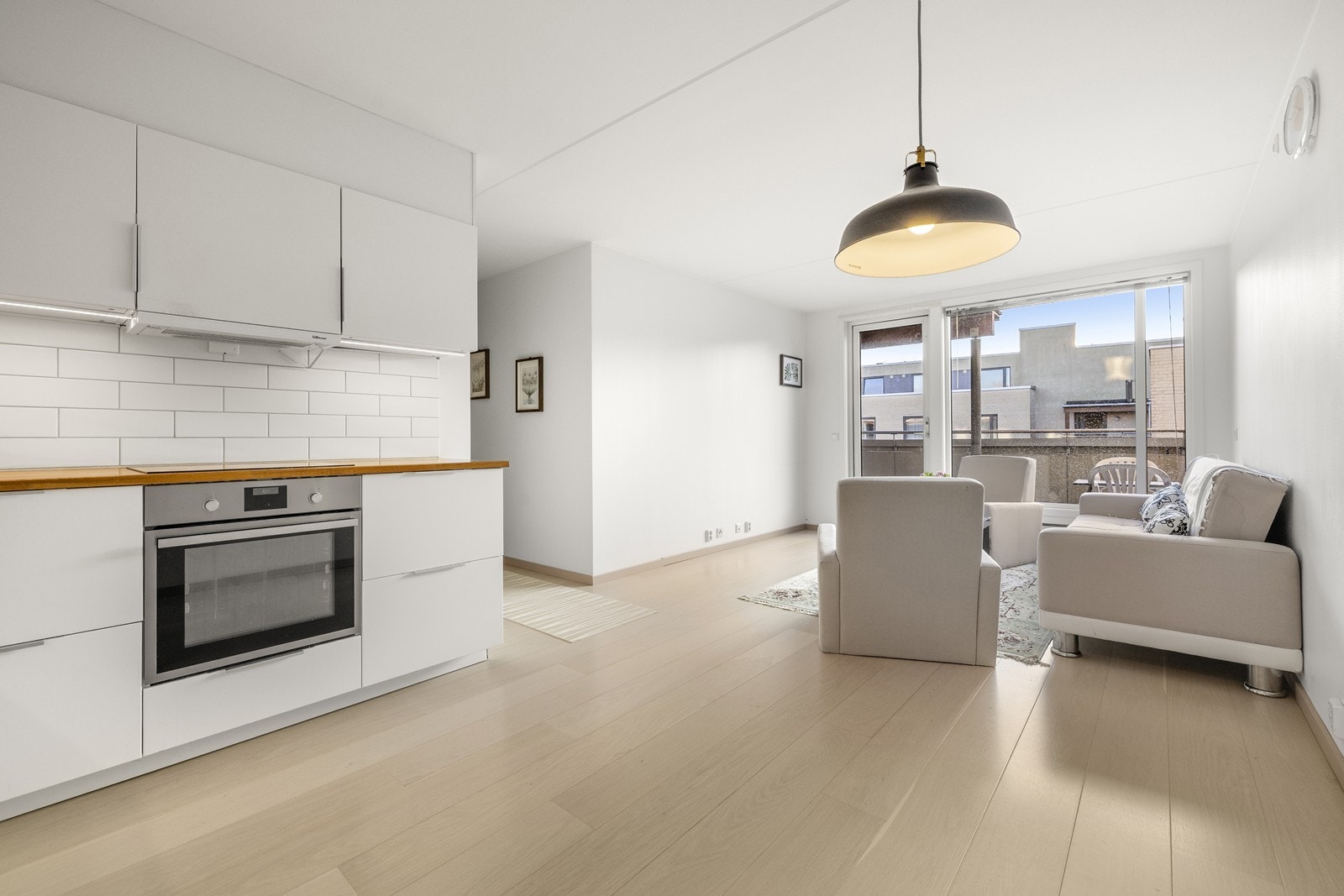 Gjennomgående laminatgulv binder sammen kjøkken- og stuesonen til en helhet. Galleribilde