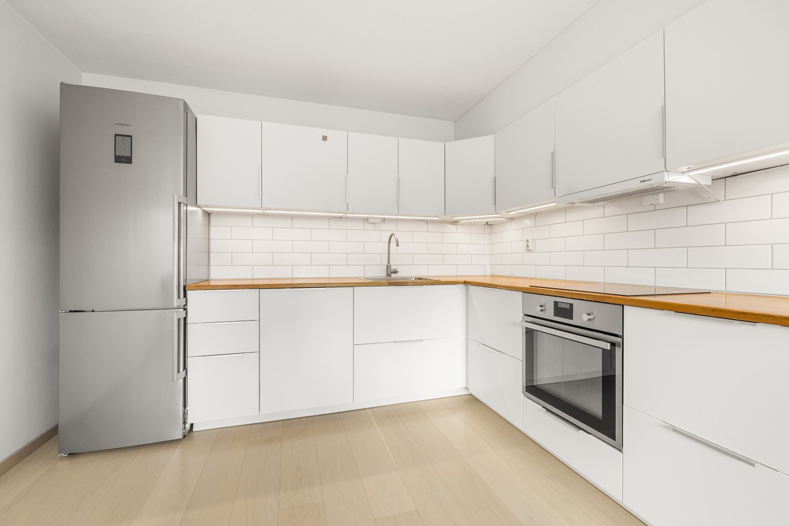 Innredningen har slette, lyse fronter og en benkeplate i tre. Galleribilde