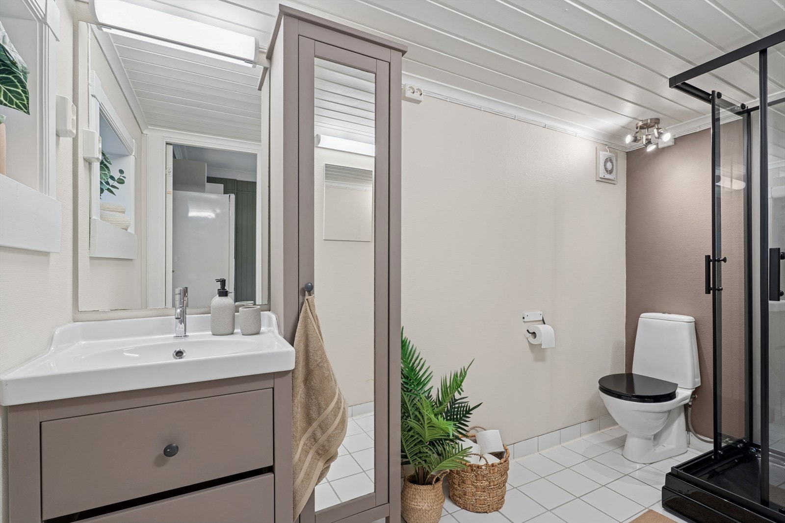 Det er tidløst innredet med sort dusjkabinett og gulvstående toalett. Det er også opplegg til vaskemaskin. Galleribilde