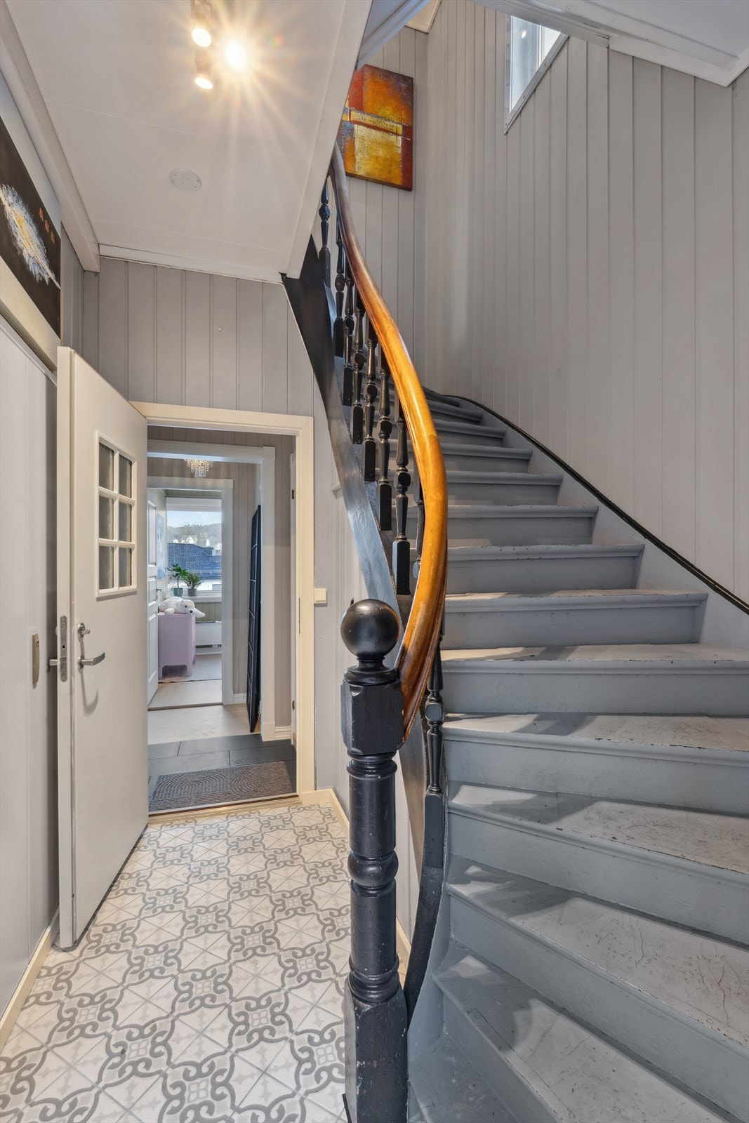 Felles inngangsparti til leiligheten i første etasje, samt leiligheten i andre etasje. Her finner vi også sikringsskapet for leilighetene og kjelleren.
Vi tar turen opp. Galleribilde